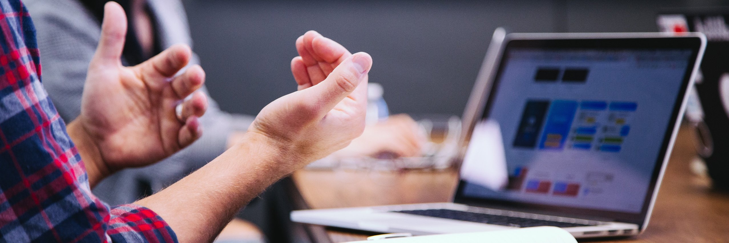Male hands in a discussing pose in front of a laptop