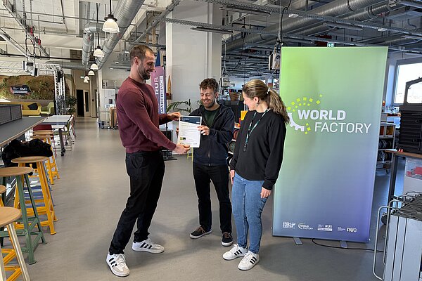 Johannes erhält das Entrepreneurship Certificate bei einer Übergabe im RUB-Makerspace.