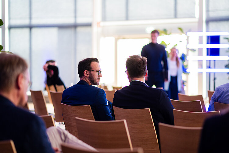 intellectual property startup Two people sitting in the audience talking to each other.