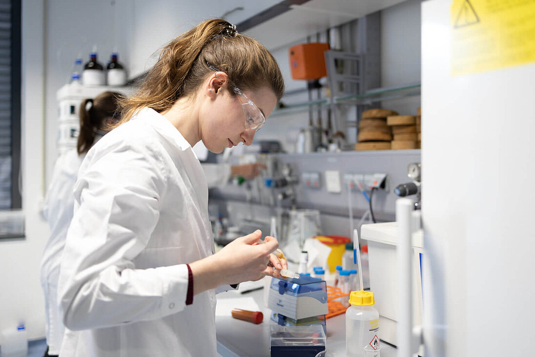 Junge Frau arbeitet im Chemie-Labor