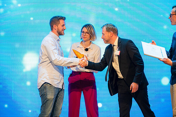 Die Gründer*innen von Glim Skin, Dr. Friederike Kogelheide und Manuel Schröder, auf der Bühne beim Senkrechtstarter Finale 2023. 