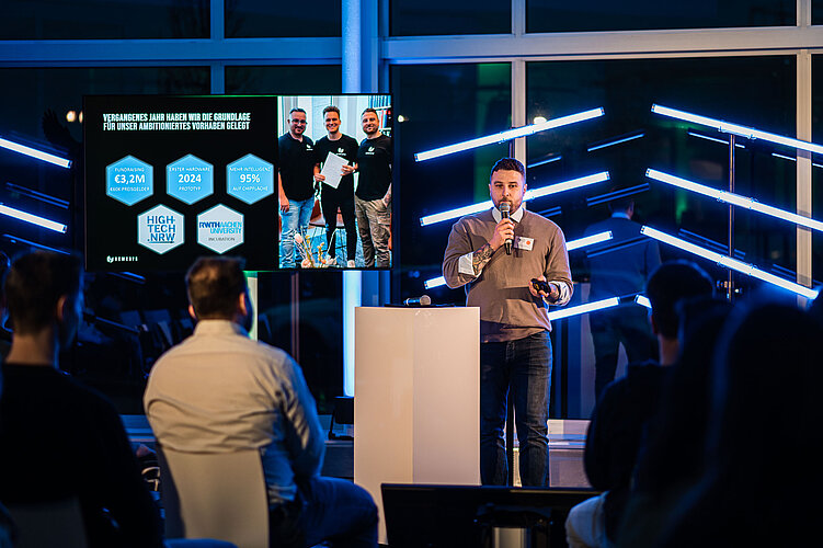 Start-up pitcht auf einer Bühne.