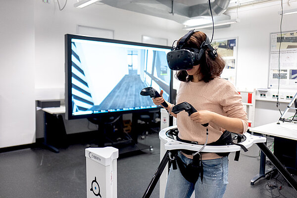 Eine Frau bewegt sich mit einer VR-Brille in der Virtual Reality-Welt.