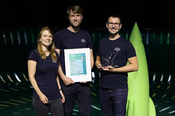 Lisa Schmitt, Steffen Wittemeier und Philip Schmitt (rechts) vom Start-up-Team mechIC bei der Preisverleihung in der Bochumer Starlight-Express-Halle.