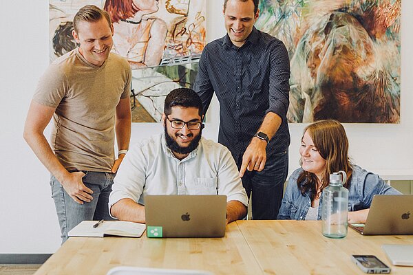 Mehrere Personen arbeiten begeistert an einem Projekt
