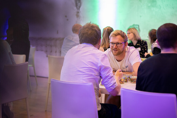 technology transfer People sit at a table and exchange ideas.
