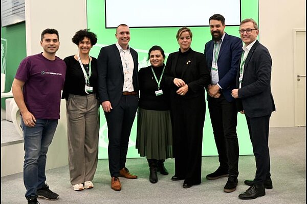 Tim Knospe und Mélisa Dangel von der Ruhr-Universität Bochum, Felix Maul von der AOK Rheinland/Hamburg, Nazan Aynur (ZENIT), NRW-Wirtschaftsministerin Mona Neubaur, Prof. Dr. Sebastian Merkel (Ruhr-Universität Bochum) und ZENIT-Geschäftsführer Jürgen Schnitzmeier (von links)